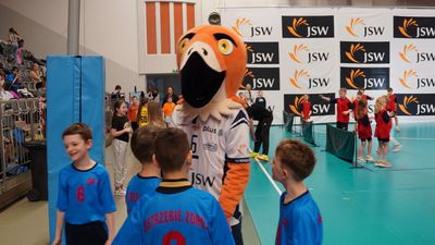 maskotka Jastrząb otoczona dziecmi w niebieskich koszulkach