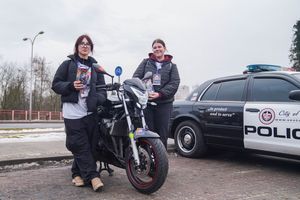 Wolontariuszki pozują z motocyklem 