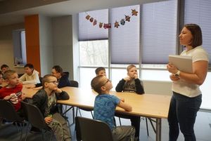Dzieci biorące udział w feriach z MOSiR-em słuchają poleceń instruktorki