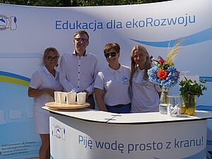 Prezydent Miasta Pan Michał Urgoł z uczestniczkami pikniku wokół stanowiska z napisem Edukacja dla Rozwoj Pij wodę prosto z kranu