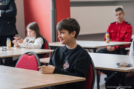 Nastolatek śmiejący sie przy stoliku