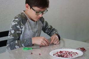 DZieci wykonujące serce z koralików podczas warsztatów z metaloplstyki