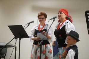 Dwie panie z koła gospodyń wiejskich i mały chłopiec w strojach ludowych