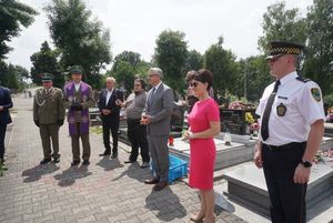 Uczestnicy uroczystości modlą się przy grobie powstańca