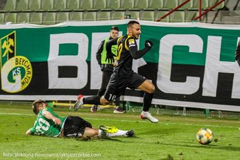 Farid Ali biegnie z piłką, a zawodnik Bełchatowa wykonuje wślizg.