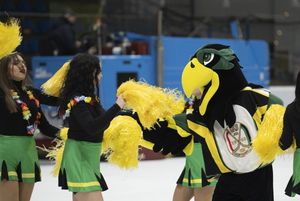 Maskotka JKH tańczy z cheerleaderkami.
