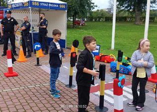 Dzieci podczas zabawy na ścieżce z mini znakami drogowymi