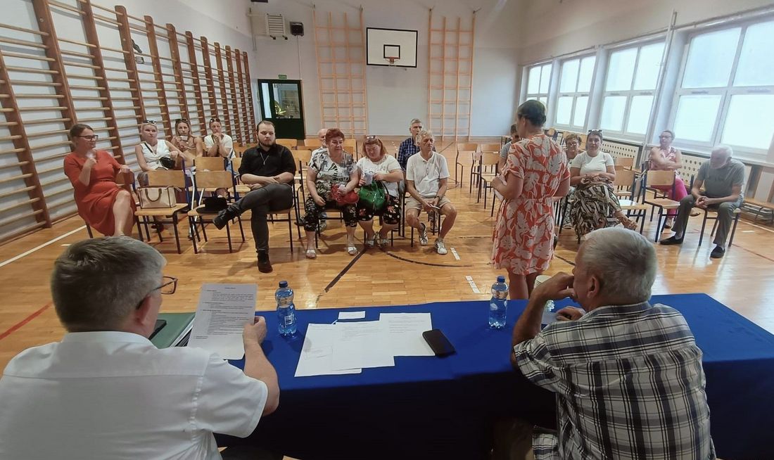 Mieszkańcy Osiedla Zdrój siedzący na krzesłach na sali gimnastycznej