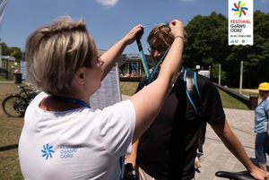 Uczestnicy rajdu rowerowego na OWN odbierają medale i robią pamiątkowe zdjęcia.