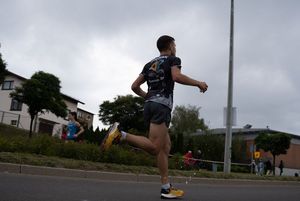 Zdjęcie przedstawia biegnącego zawodnika biegu głównego.