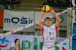 Kampa rozgrywa piłkę nad siatką.