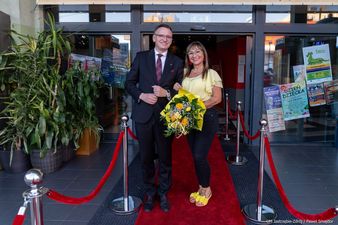 Prezydent Michał Urgoł stoi z kobieta w żółtej bluzce, żółtych butach i z bukietem kwiatów