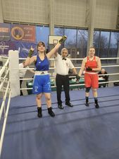 Sędzia podnoszący rękę bokserki po zwycięskiej walce