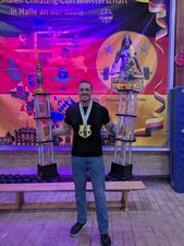 Dennis Sitek z dwoma wielkimi trofeami w rekach oraz medalem na szyi