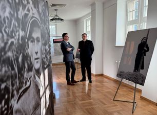 Prezydent Miasta Michał Urgoł rozmawiający z Dyrektorem Muzeum Miejskiego Jędrzejem Lipskim, wokół zdjęcia z czasów powojennych