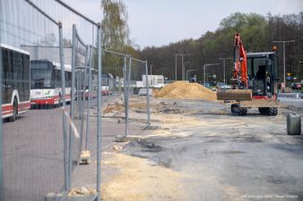 odgrodzony metalowy płotem plac budowy po prawej stronie czerwona koparka