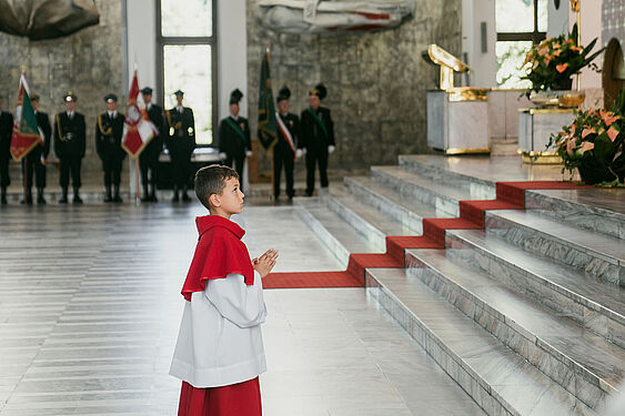 Młody ministrant modli się przed ołtarzem