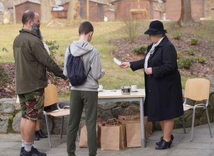 Kobieta przekazująca instrukcje uczestnikom gry terenowej