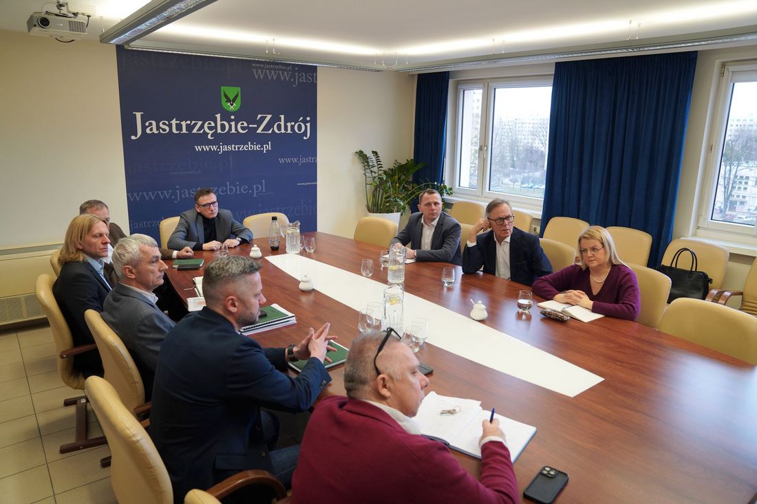 Przedstawiciele Katowickiej Specjalnej Strefy Ekonomicznej na spotkaniu w Urzędzie Miast siedzą przy stole z prezydentem i zastępcą oraz urzędnikami