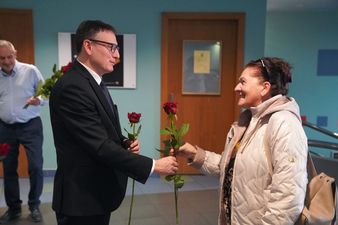 Prezydent wręcza róże pani w holu kina centrum z okazji dnia kobiet