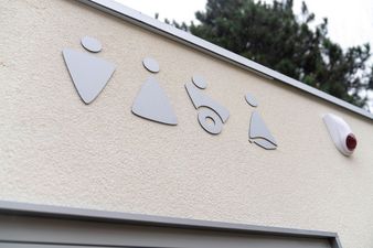 Na górnej części ściany naklejone oznaczenia płci