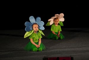 dzieci przebrane za kwiaty tańczą na scenie