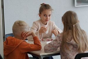 Dzieci wykonujące serce z koralików podczas warsztatów z metaloplstyki