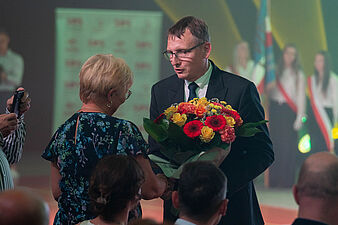 Prezydent Michał Urgoł wręcza bukiet kwiatów