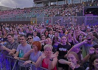 Widownia na stadionie podczas koncertu, ludzie machają ramionami