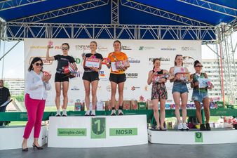 najszybsze sześc kobiet biegu stoi na podium na scenie wraz z dyrektor Zofią Florek