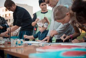 Warsztaty plastyczne - dzieci i dorośli malują farbami.