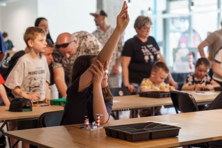 Dziewczyna podnosząca dłoń w celu zabrania głosu