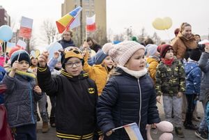 Dzieci w wieku przedszkolnym z chorągiewkami polskimi i ukraińskimi na placu WOŚP.