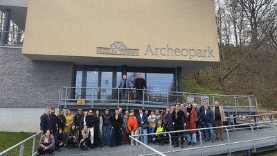 Zdjęcie grupowe uczestników na tle budynku o nazwie Archeopark muzeum tesinska