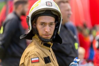 strażak w piaskowym mundurze i białym hełmie