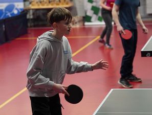 Zchłopiec grający przy stole do ping-ponga