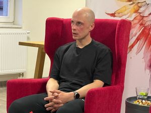 Zbliżenie postaci Mateusza Nędzy w czerwonym fotelu
