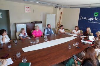 członkowie Rady podczas posiedzenia siedzą przy stole
