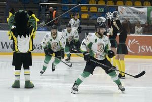 Hokeiści wyjeżdżają na lód w asyście klubowej maskotki i cheerleaderek.