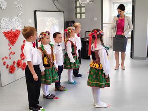 Grupa dzieci w strojach ludowych podczas uroczystości