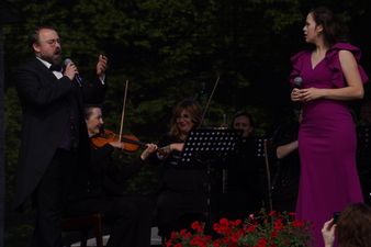 Tenor ubrany w smoking śpiewający do tenorki ubranej w fioletową sukienkę
