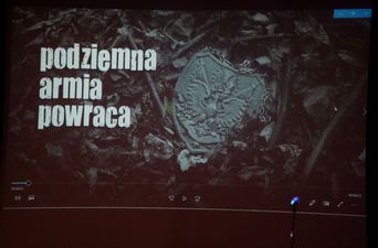 plansza na ekranie z godłem Reczpospolitej Polski oraz napisem podziemna armia powraca