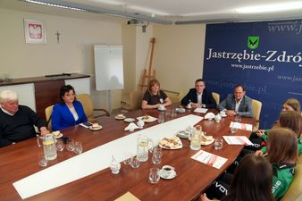 Ujęcie szerokie, uczestnicy spotkania siedzą przy stole