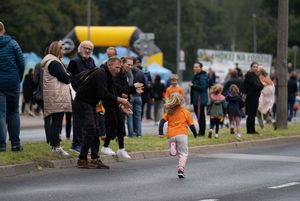 Zdjęcie przedstawia biegnących zawodników oraz kibiców.