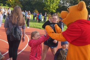 Uczestnicy pikniku z animatorem przebranym za Kubusia Puchatka