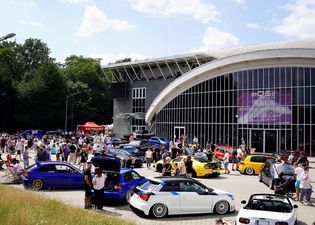 ekspozycja otwarta na wystawe samochodów i tłum ludzi pomiedzy nimi