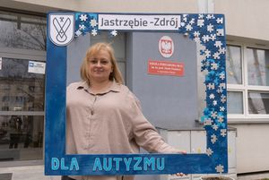 Beata Skowrońska trzyma drewnianą, niebieską ramkę z napisem "dla autyzmu"