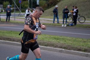 Zdjęcie przedstawia biegnącego zawodnika biegu głównego.