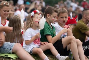 Dzieci również oglądają mecz i jedzą watę cukrową.