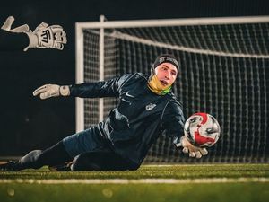 Bramkarz podczas interwencji po strzale w lewym dolnym rogu podczas sparowania piłki